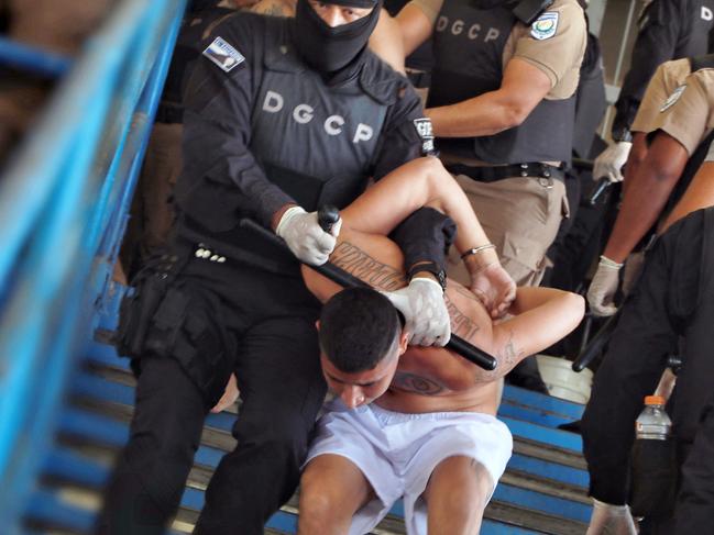 Handout picture released by the press secretary of the Salvadorean Presidency on March 28, 2022 showing gang members of the Mara Salvatrucha and Barrio 18 gangs being taken by security forces to a patio of the prison in Ciudad Barrios, El Salvador, during the weekend, after the rise in homicide figures that occurred over the past days. - El Salvador's President Nayib Bukele issued an ultimatum on March 28, 2022, to gangs considered responsible for dozens of homicides in the ast three days, threatening to increase punishments on their more than 16,000 imprisoned members. The Central American nation declared a state of emergency on Sunday as it endures a fresh wave of gang violence, with police reporting 87 dead since Friday. (Photo by EL SALVADOR'S PRESIDENCY PRESS OFFICE / AFP) / RESTRICTED TO EDITORIAL USE - MANDATORY CREDIT "AFP PHOTO / SALVADOREAN PRESIDENCY" - NO MARKETING - NO ADVERTISING CAMPAIGNS - DISTRIBUTED AS A SERVICE TO CLIENTS