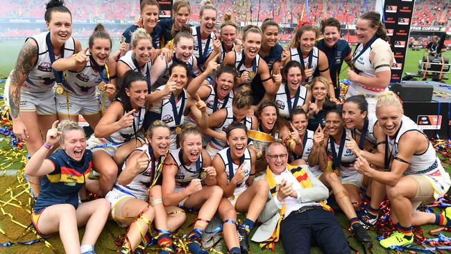 Former SA Premier Jay Weatherill jumps in for a photo with the Adelaide Crows’ AFLW team after winning the 2017 grand final. Picture: AAP Image/Dan Peled