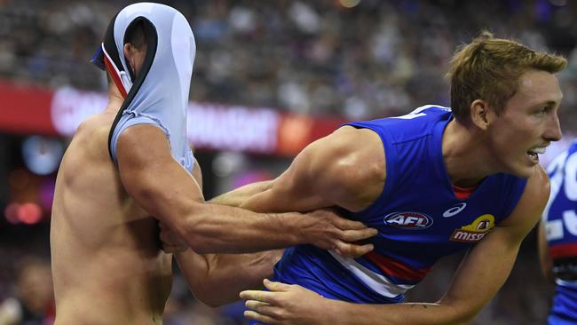 An upset Conor McKenna (left) tangles with Bailey Dale after he was caught holding the ball.