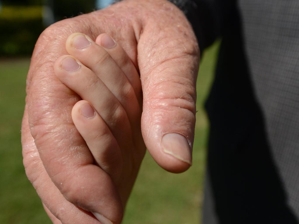 An old man's hand holding a child's hand. Photo Brenda Strong / The Observer.