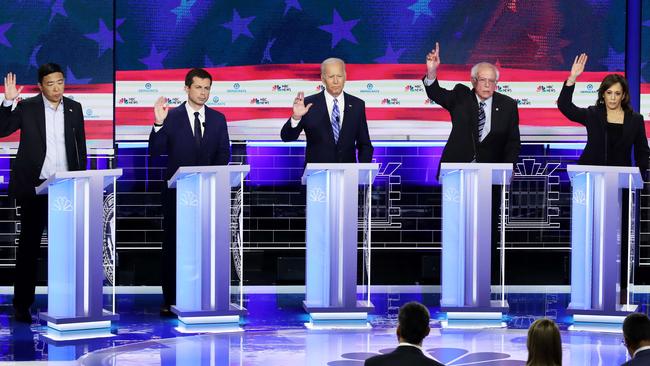 Democratic presidential candidates raise their hands raise their hands in agreement when asked whether illegal immigrants should be given access to healthcare. Picture: Drew Angerer/Getty/AFP