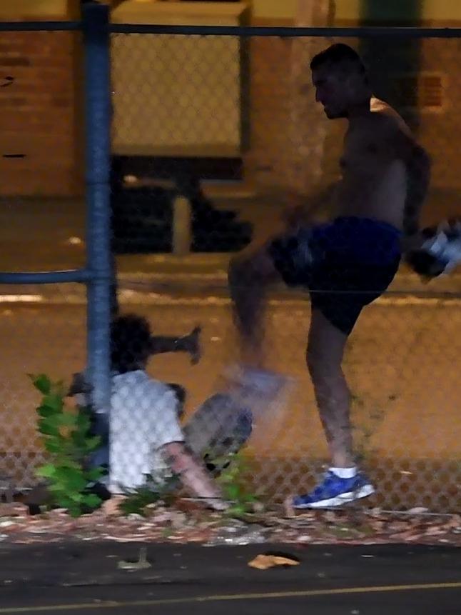 A man is pinned to fence and kicked in head.