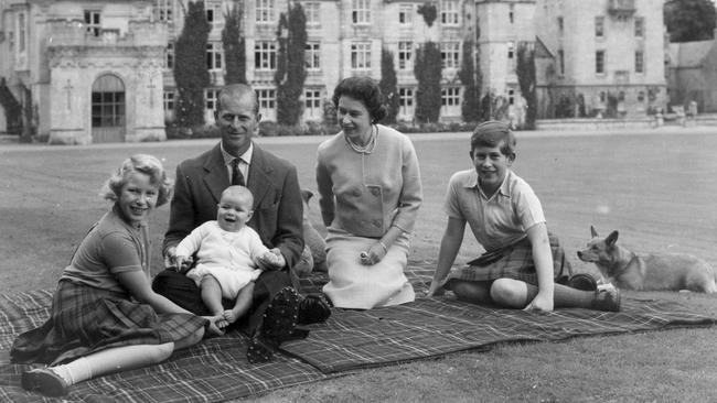 Queen Elizabeth II and Prince Philip, Duke of Edinburgh, with their children, (from left) Princess Anne, Prince Andrew and Charles, Prince of Wales, sitting on a picnic rug outside Balmoral Castle in Scotland in 1960. Picture: Keystone/Getty Images