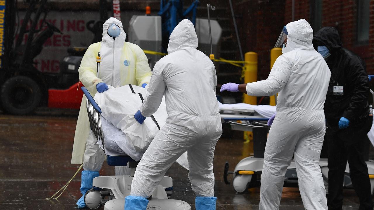 Medical personnel move a deceased patient to a refrigerated truck serving as make shift morgues at Brooklyn Hospital Centre on April 09, 2020 in New York City. Picture: Angela Weiss/AFP.