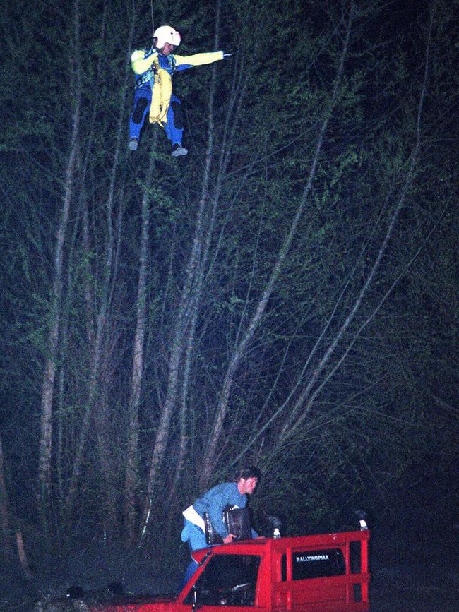 Paramedic Ian Spencer is winched down from helicopter to rescue Lance White, stranded on top of his 4WD ute after it was washed off track &amp; into swollen Nepean River.