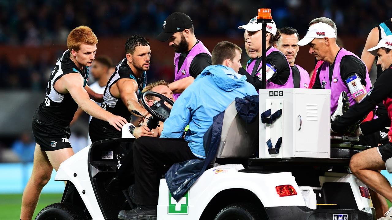 Willem Drew and Travis Boak of Port Adelaide console Jack Watts as he is taken from Adelaide Oval. Picture: Mark Brake/Getty Images