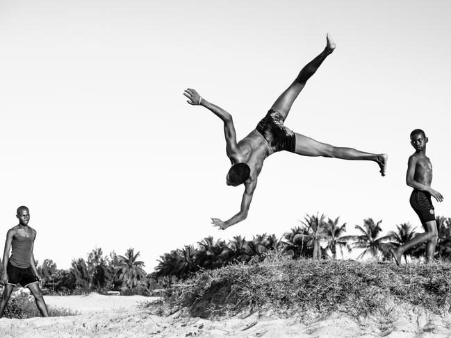 Photo of the Year winner: Tim Baskerville ... The skin contrast, the sand stuck to their bodies, the triangular composition and the natural leading lines from the looks: it’s the small details that make Tim Baskerville’s shot the clear winner in our Photograph of the Year category. Baskerville says the image was taken on his last day in Madagascar, where he had been living and working for three months for an organisation called Mercy Ships. “Across from the port was a stretch of beach which was always full of life,” he said. “I came across three kids using a small mound of sand for a kicker. These little Malagasy ninjas blew me away with their skills, and I sat there for an hour mesmerised. After I had taken the shot I showed them and they looked at each other and just burst out laughing. It was a great moment.” Picture: Tim Baskerville/Australian Photography magazine