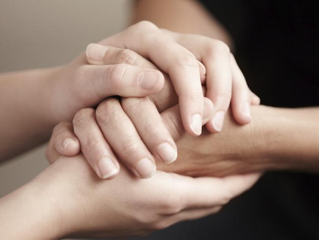 Two people's hands being held tightly together