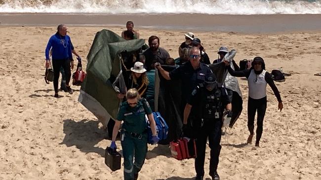 Bridgette O'Shannessy is carried off the beach at the Port Noarlunga jetty on Friday. Picture: 7 NEWS