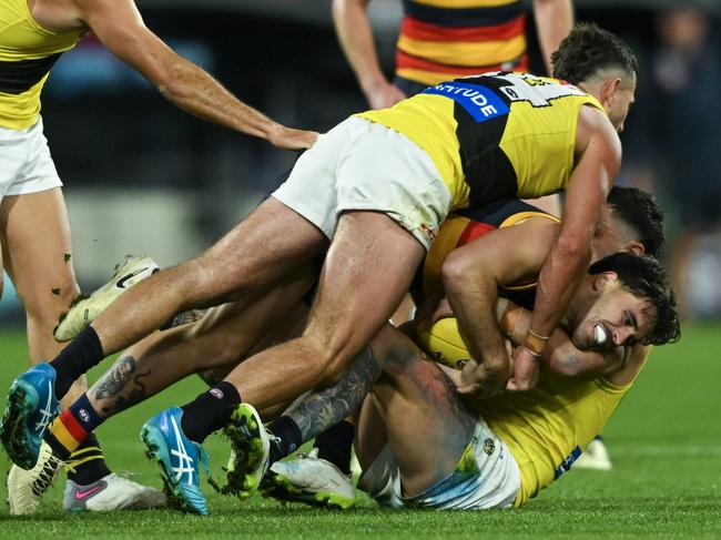 ADELAIDE, AUSTRALIA - JUNE 06:  Lachlan Murphy of the Crows  tackled by  Jack Graham  and  Tim Taranto of the Tigers  during the round 13 AFL match between Adelaide Crows and Richmond Tigers at Adelaide Oval, on June 06, 2024, in Adelaide, Australia. (Photo by Mark Brake/Getty Images)