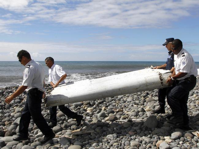 epa04911079 (FILE) A file photo dated 29 July 2015 showing officers carrying a flaperon  from an aircraft apparently washed ashore in Saint-Andre de la Reunion, eastern La Reunion island, France. French officials said 'with certainty' on 03 September 2015 that the flaperon found on La Reunion island in July came from missing flight MH370, according to media reports.  EPA/RAYMOND WAE TION FRANCE OUT, CORBIS OUT, BELGIUM OUT