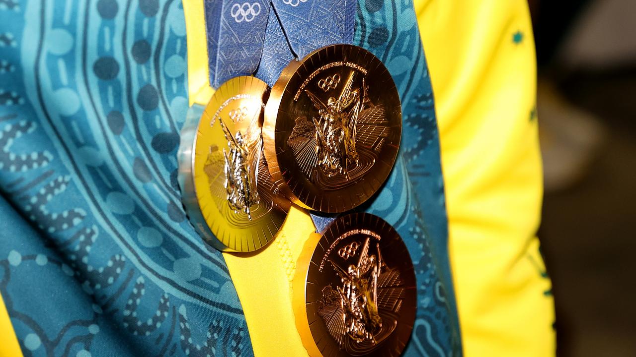 Titmus showed off her Olympic medals on arrival at Sydney airport. Picture: Jason McCawley/Getty Images