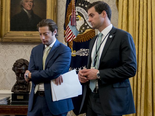 White House aide Johnny McEntee, right, and Treasury Secretary Steve Mnuchin's Chief of Staff Eli Miller, left, stand in the Oval Office. Picture: AP