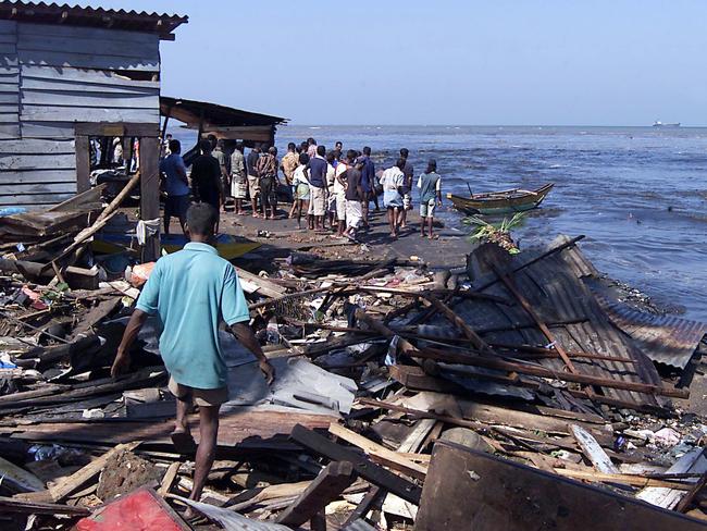 Earthquake and tidal waves in Asia.  People walking through debris of their homes along the coast of Colombo, Sri Lanka 26 Dec 2004.  destroyed damage wave tsunami