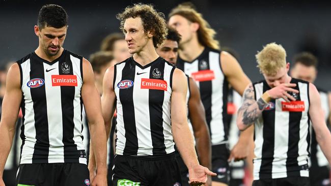 Dejected Pies Scott Pendlebury and Chris Mayne lead their beaten charges off the MCG. Picture: Getty Images