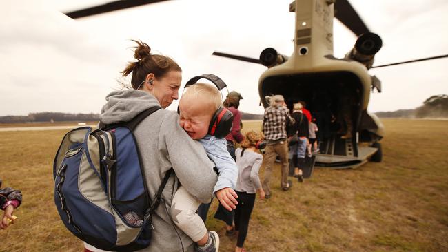 The last of the remaining evacuees were airlifted out of Mallacoota Airport by ADF chinook helicopters. Picture: David Caird