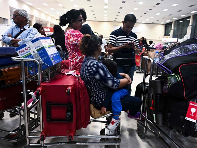 Passengers wait inside the arrival hall at Bandaranaike International Airport in Katunayake after authorities imposed a curfew following eight bomb blasts in the country. Picture: AFP