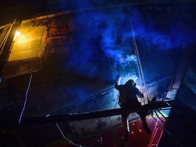 A Bangladeshi labourer works in a dockyard beside the Buriganga River in Dhaka on August 2, 2017. Twenty-eight dockyards occupying 30.96 acres of the Buriganga foreshore have been in operation for the last 50 years without any authorisation or guidelines, polluting the river and encroaching into the riverbank, reducing its navigability. Picture: AFP PHOTO