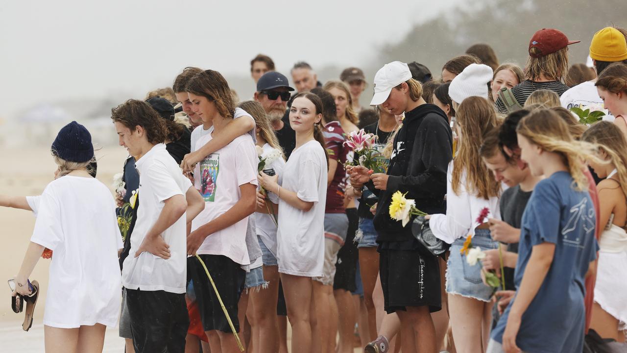 Family and friends of 16-year-old alleged stabbing victim Balin Stewart gather to pay tribute on his home beach at Buddina. Picture: Lachie Millard