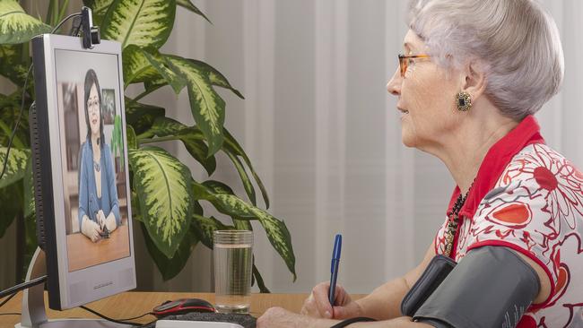 A lady measures her blood pressure during a telehealth check up with her doctor. Picture: iStock