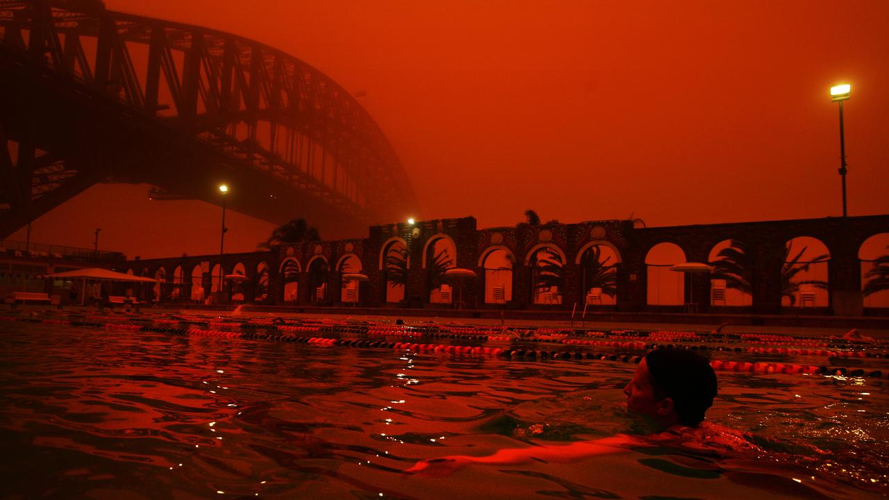 23/09/2009. Swimmers take an early morning swim at North Sydney pool as a red haze blankets Sydney from a dust storm created by overnight inland winds.