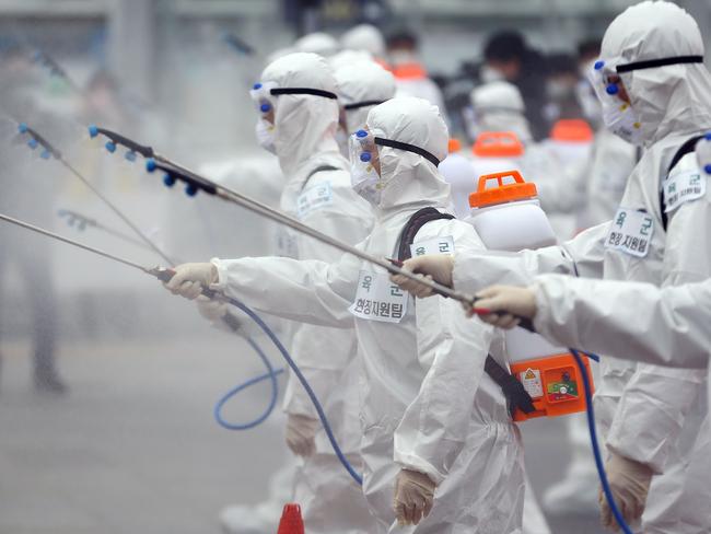 South Korean soldiers wearing protective gear spray disinfectant as part of preventive measures against the spread of the coronavirus. Picture: AFP