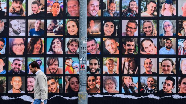 A man walks past a giant billboard featuring portraits of Israeli hostages held in Gaza since the October 7 attack by Hamas militants. Picture: John MacDougall/AFP