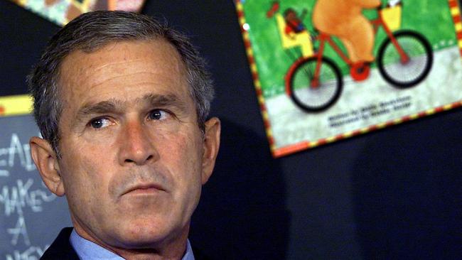 US President George W Bush reacts after having his early morning school reading event interrupted by his Chief of Staff in Sarasota, Florida, shortly after news of an aeroplane crash into World Trade Centre.