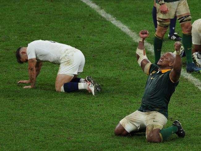 South Africa's hooker Bongi Mbonambi (R) raises his arms and sinks to his knees as he celebrates South Africa's victory at the end of the France 2023 Rugby World Cup semi-final match between England and South Africa at the Stade de France in Saint-Denis, on the outskirts of Paris, on October 21, 2023. (Photo by Thomas SAMSON / AFP)