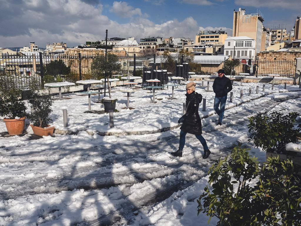 People make their way through the snow in the tourist area of Plaka in Athens. Picture: Milos Bicanski/Getty Images