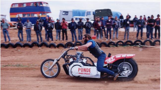 Hell's Angel Mark 'Tomo' Thompson drags his V8 Chevrolet-powered motorcycle along the sand track at Ponde rock music festival, held by the Hell's Angels Motorcycle Club in Ponde near Mannum, SA, 23 Feb 1992.
