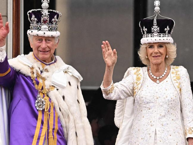 -- AFP PICTURES OF THE YEAR 2023 --  Britain's King Charles III wearing the Imperial state Crown, and Britain's Queen Camilla wearing a modified version of Queen Mary's Crown wave from the Buckingham Palace balcony after viewing the Royal Air Force fly-past in central London on May 6, 2023, after their coronations.. The set-piece coronation is the first in Britain in 70 years, and only the second in history to be televised. Charles will be the 40th reigning monarch to be crowned at the central London church since King William I in 1066. (Photo by Oli SCARFF / AFP) / AFP PICTURES OF THE YEAR 2023