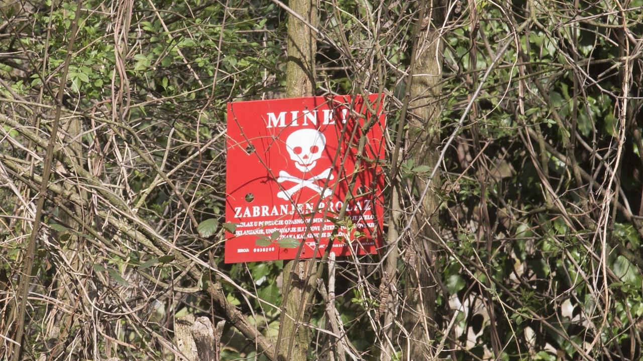 EMBARGO APPLIES - DO NOT PUBLISH BEFORE 14 MAY 2016 .. OSVE, BOSNIA. March 2016 - A mine sign around the village of Osve, a community of Salafist Islamists who dismiss claims they are running a terrorist camp amid their fields of fruit and vegetables but admit many of its members have left to fight with the group in Syria. Picture Ella Pellegrini