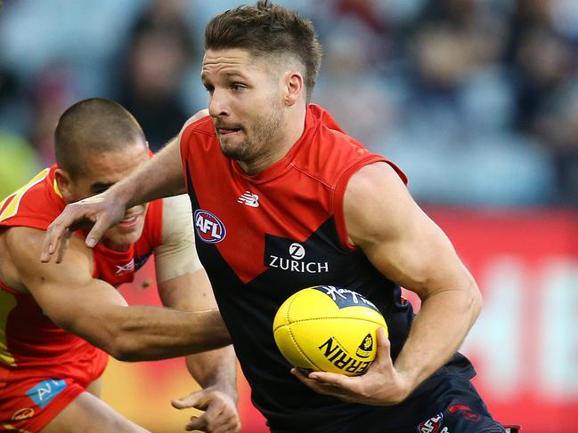 AFL Round 20. 05/08/2018. Melbourne v Gold Coast Suns at the MCG.  Melbourne's Jesse Hogan breaks the tackle of Gold Coast Suns' Jacob Dawson  .Pic: Michael Klein