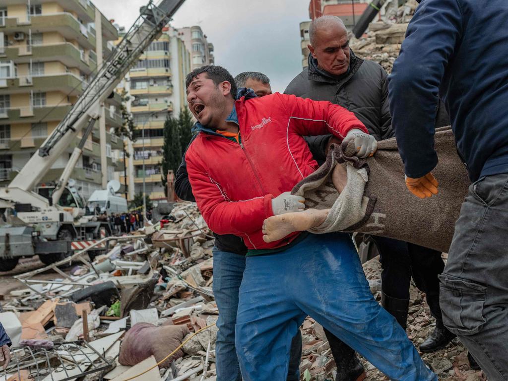 A rescuer reacts as he carries a body found in the rubble in Adana, Turkey. Picture: AFP