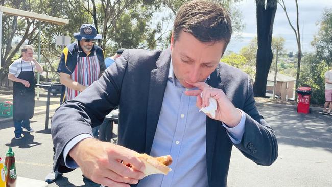 Liberal leader Matthew Guy tucks into a democracy sausage at a polling booth in Templestowe on election day. Picture: Rebecca Michael