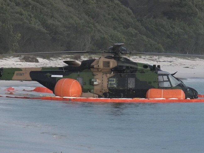 The MRH-90 Taipan helicopter is seen in shallow water on the beach after crashing off Jervis Bay. Picture: TNV