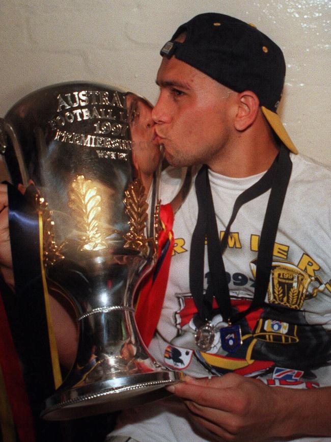 Andrew McLeod, wearing the Norm Smith Medal, and kissing the 1997 Premiership cup.