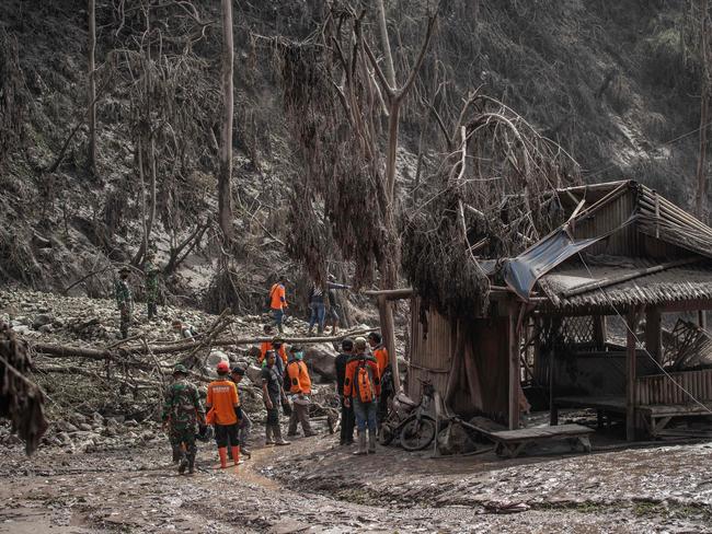 Rescue personnel search for villagers in an area covered in volcanic ash at Sumber Wuluh village. Picture: AFP