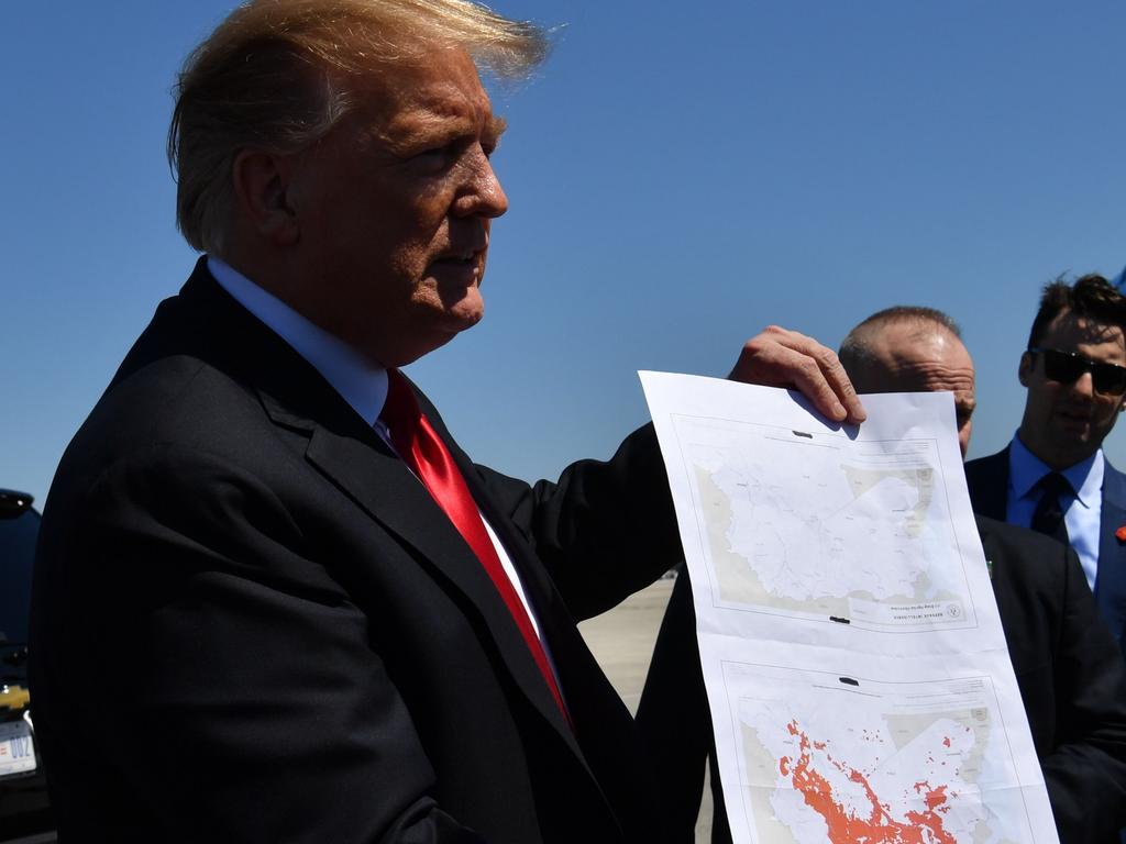 US President Donald Trump show a map which he said indicates the end of ISIS, as he arrives at Palm Beach International Airport in Florida on March 22, 2019. Picture: Nicholas Kamm/AFP