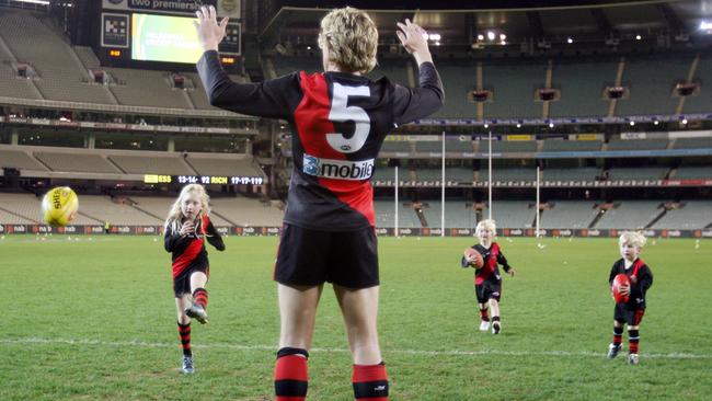 Stephanie and her brothers join dad for a kick on the MCG after James Hird’s final AFL game in Melbourne.