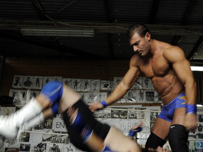 Huseyin Gul (blue shorts) in action in the wrestling ring.