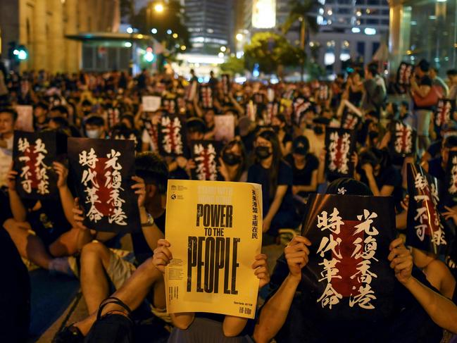 Pro-democracy protesters hold signs as they attend a rally in Hong Kong on August 16, 2019. - Hong Kong's pro-democracy movement faces a major test this weekend as it tries to muster another huge crowd following criticism over a recent violent airport protest and as concerns mount over Beijing's next move. (Photo by Manan VATSYAYANA / AFP)