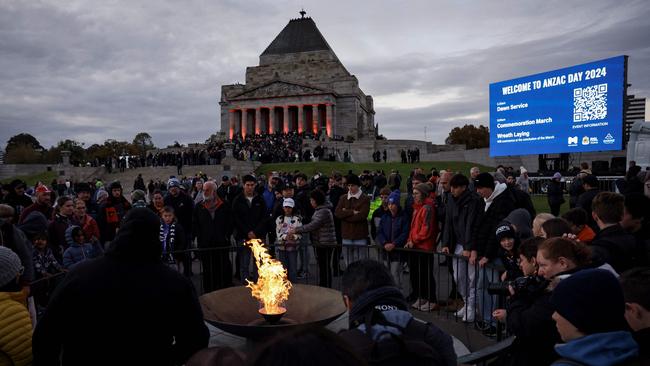 People pay their respects at the eternal flame during the Anzac Day dawn service at the Shrine of Remembrance in Melbourne. Picture: AFP