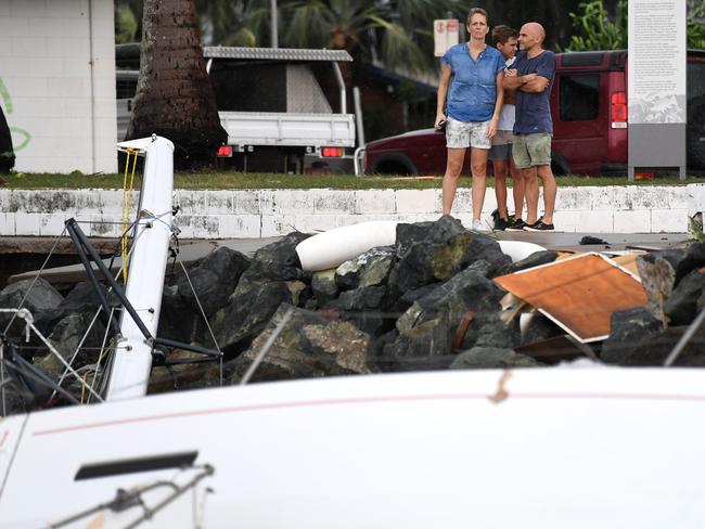 Locals inspect boats that smashed agains rocks at Shute Harbour, Airlie Beach, Wednesday, March 29, 2017. Picture: AAP Image/Dan Peled