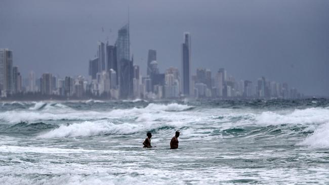 Wet weather on the Gold Coast. Swimmers take a dip in wet weather at Burleigh Heads. Picture: NIGEL HALLETT