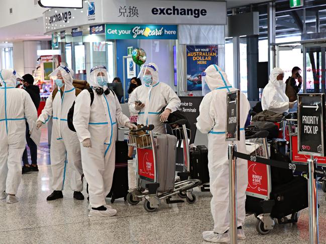 People in full PPE arriving at Sydney International Airport. Picture: Adam Yip