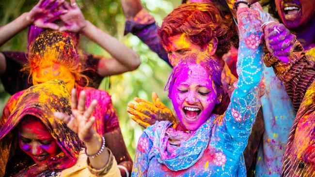 Indian Friends Dancing Covered on Holi colorful powder in India