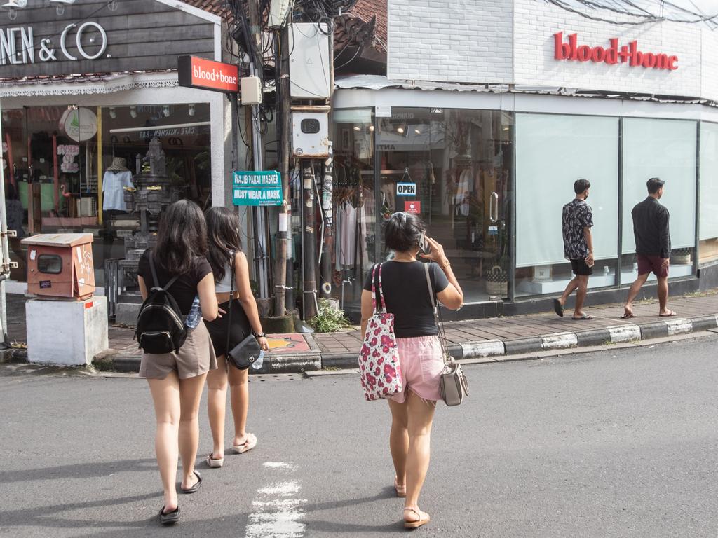 Pedestrians cross a street in Seminyak, Bali. Picture: Getty Images