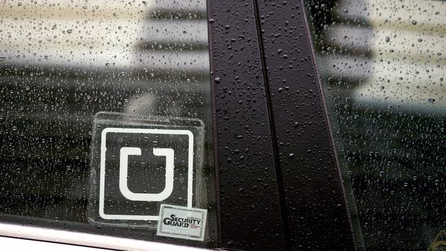 The Uber Technologies Inc. logo is displayed on the window of a vehicle after dropping off a passenger at Ronald Reagan National Airport (DCA) in Washington, D.C., U.S., on Wednesday, Nov. 26, 2014. Uber Technologies Inc. investors are betting the five-year-old car-booking app is more valuable than Twitter Inc. and Hertz Global Holdings Inc. Photographer: Andrew Harrer/Bloomberg